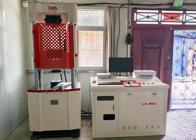 Equipo en posición | Nuestra máquina de prueba universal servo electro-hidráulica completa con éxito el cliente en el sitio